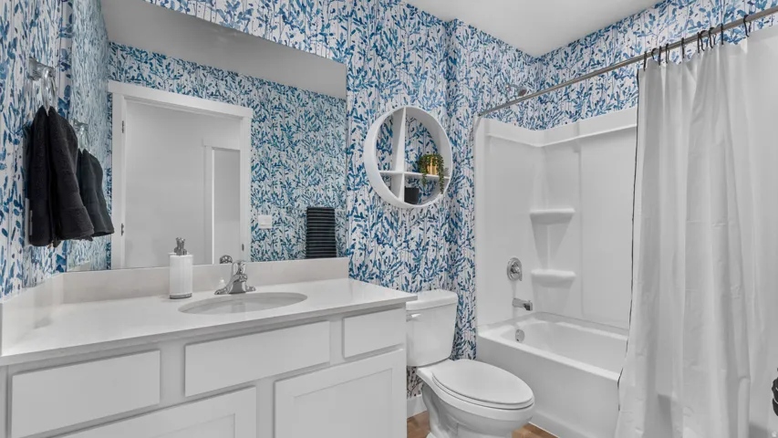 White vanity with a single basin sink, white quartz countertop, and chrome faucet