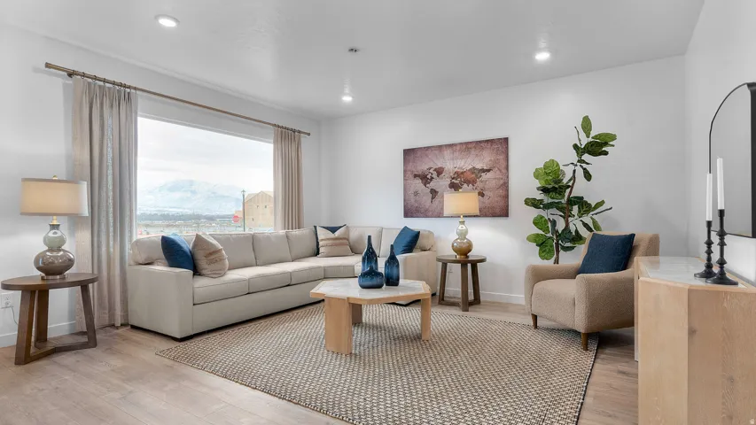 Spacious living area featuring wood-finish flooring, recessed lighting, and a large picture window