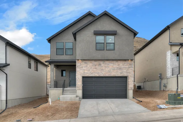 Contemporary exterior with a two-car garage, stone accent siding, and multiple windows