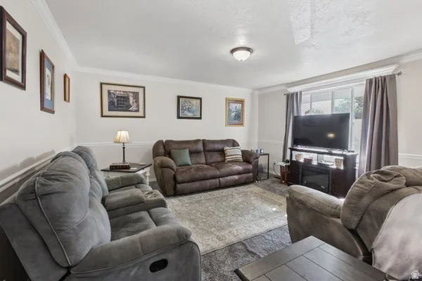 Living area featuring crown molding, neutral wall tones.