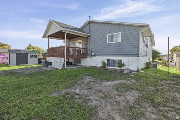 Exterior featuring a covered deck, 2 detached storage sheds