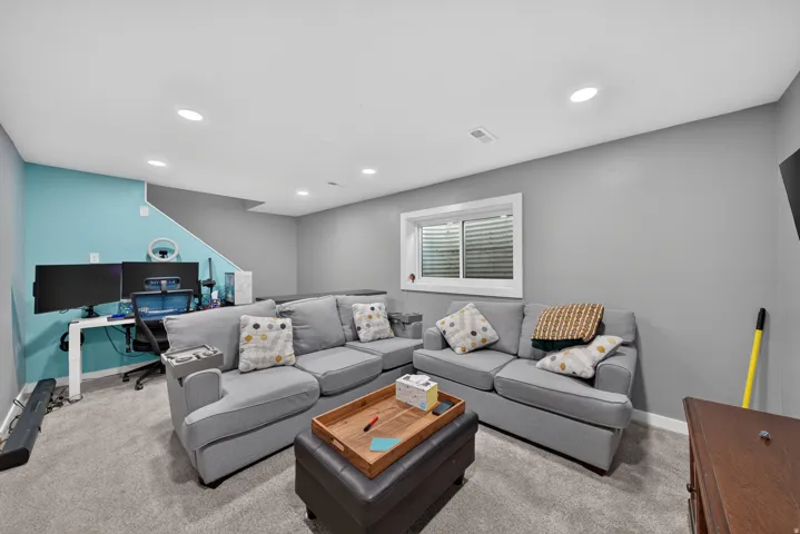 Recessed lighting, wall-to-wall carpeting, and a white-framed window