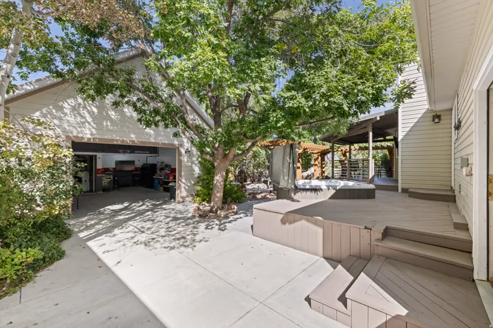 Shaded Backyard Deck with Hot Tub, Detached Garage, & Workshop.