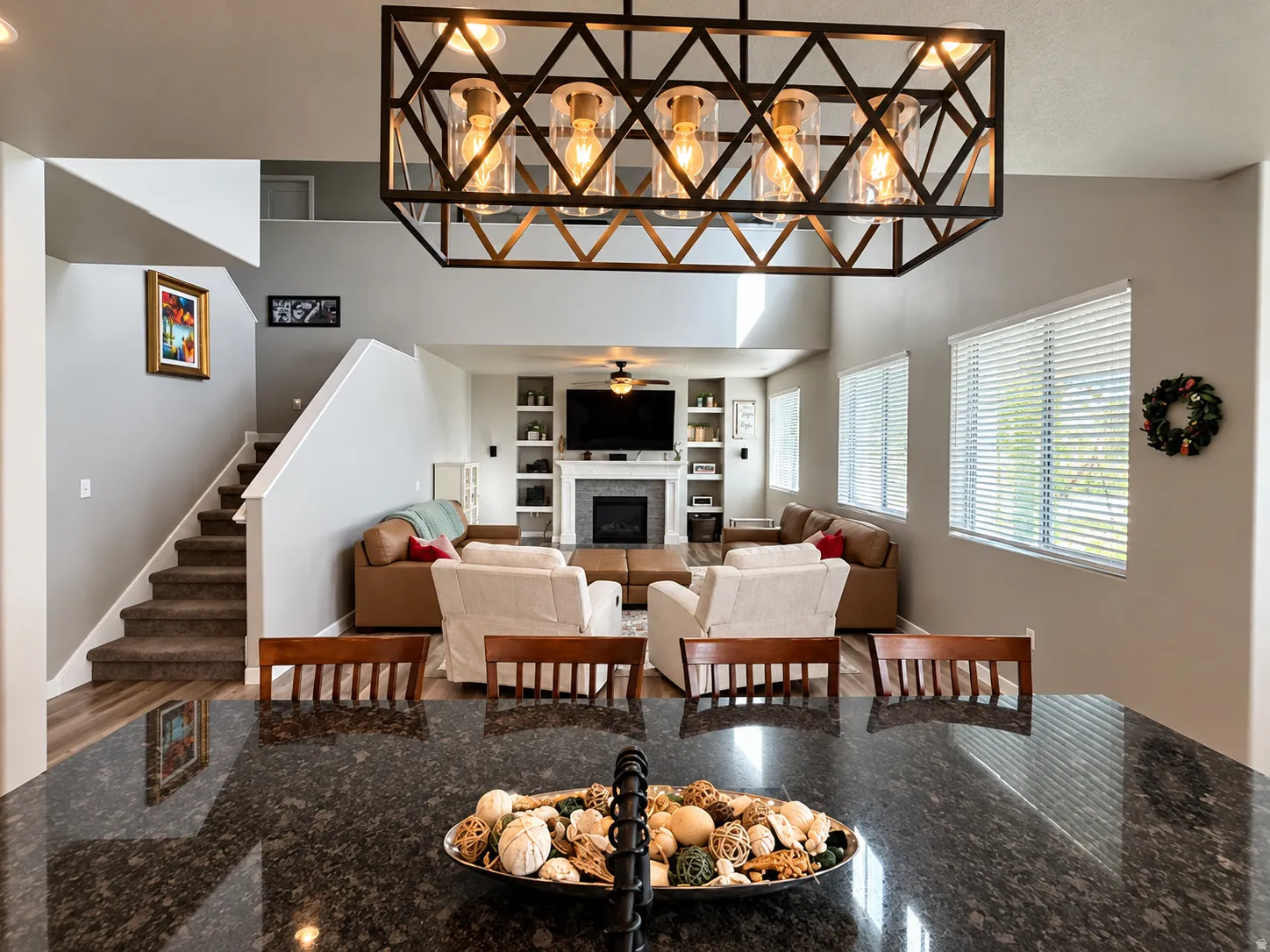 Two-story living area with a vaulted ceiling, a built-in fireplace, and integrated shelving