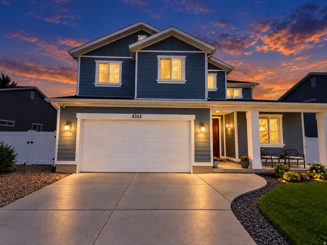 Two-story exterior with horizontal siding, a covered entry porch, an attached garage, and a concrete driveway