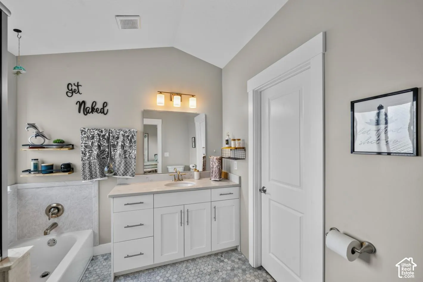 White vanity with a light-toned countertop, undermount sink, and brushed nickel faucet