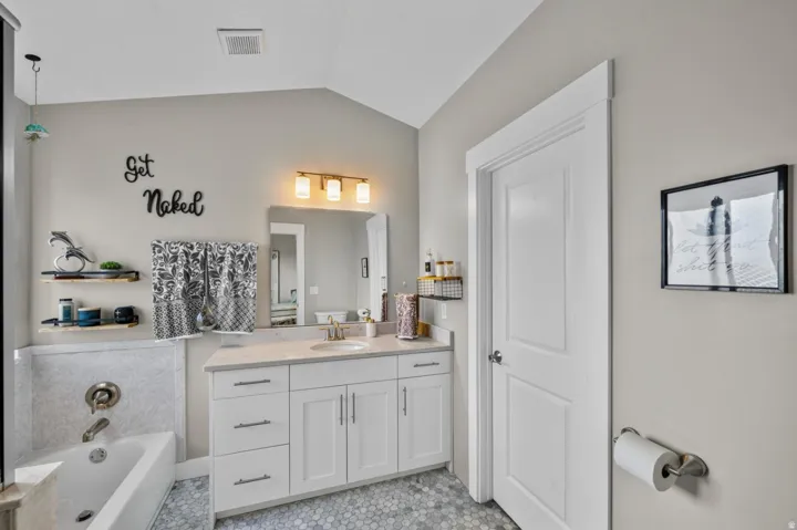 White vanity with a light-toned countertop, undermount sink, and brushed nickel faucet
