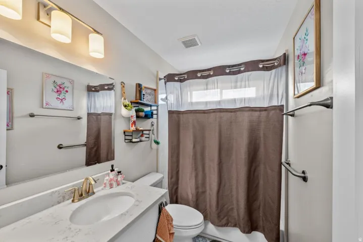 Vanity with integrated sink, gold-finish faucet, and full-width mirror