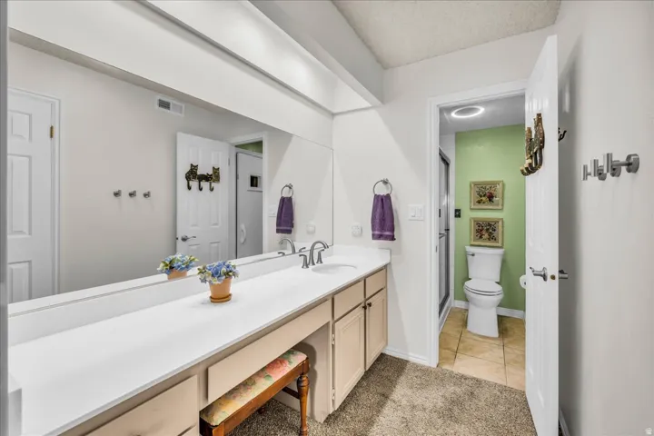 Long vanity with integrated dual sinks, recessed lighting, and a full-width mirror