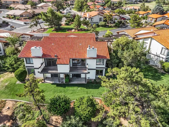 Two-story residence featuring a terracotta tile roof, white exterior, and multiple balconies