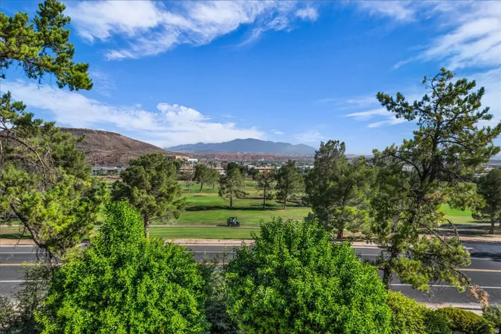 Expansive golf course frontage with mature trees and mountain scenery