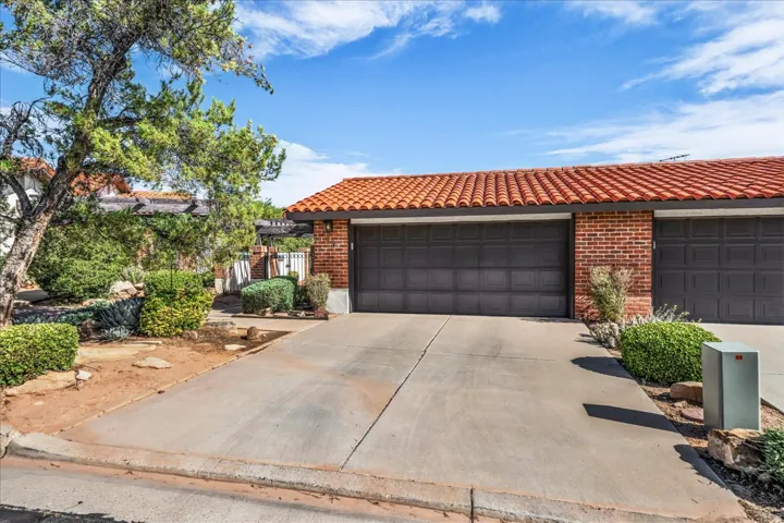 Concrete driveway leading to a two-car garage with panel doors