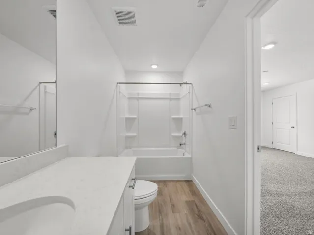 White vanity with integrated sink, light-toned countertop, and chrome hardware