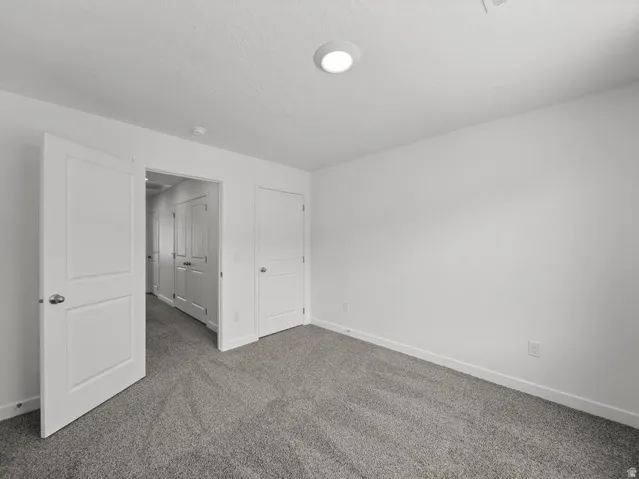 Recessed ceiling lighting, light gray wall-to-wall carpeting, white interior doors, and white painted walls