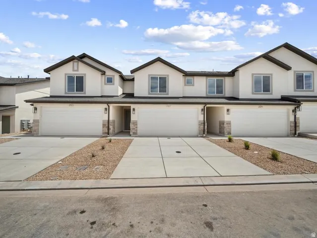 Stucco exterior with stone accents, attached garages, and concrete driveways