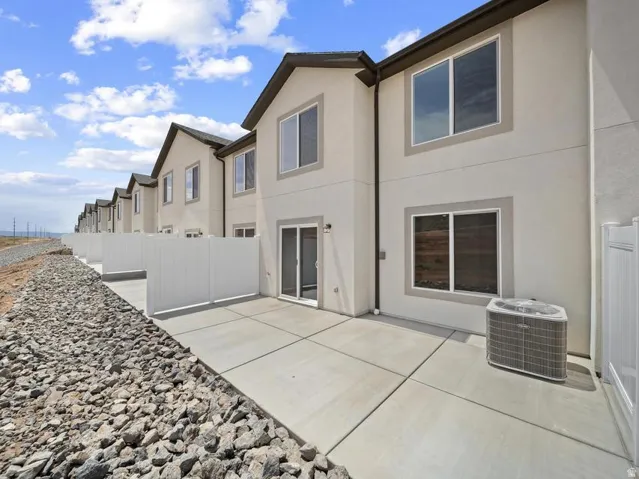 Private patio with concrete surfacing, white privacy fencing, and exterior lighting