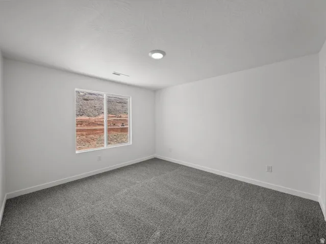 Recessed lighting, light gray carpeting, neutral wall finishes, and a single window