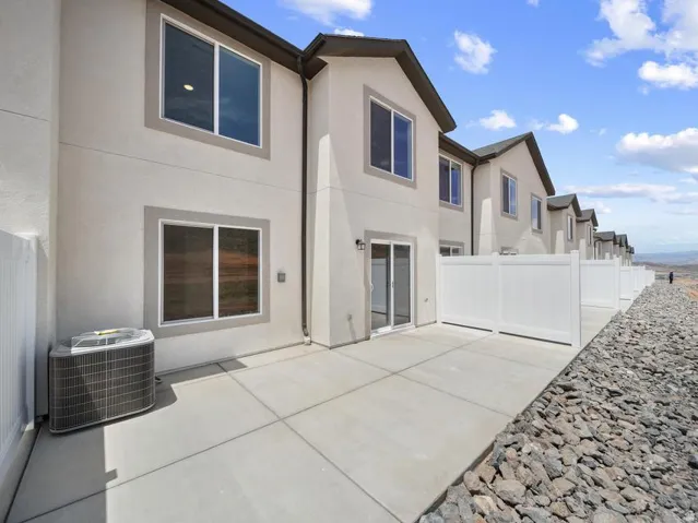 Private patio space with concrete paving, white privacy fencing, and a sliding glass door entry