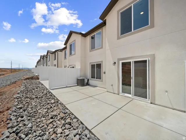 Private patio with concrete surfacing, white vinyl fencing, and direct sliding glass door access