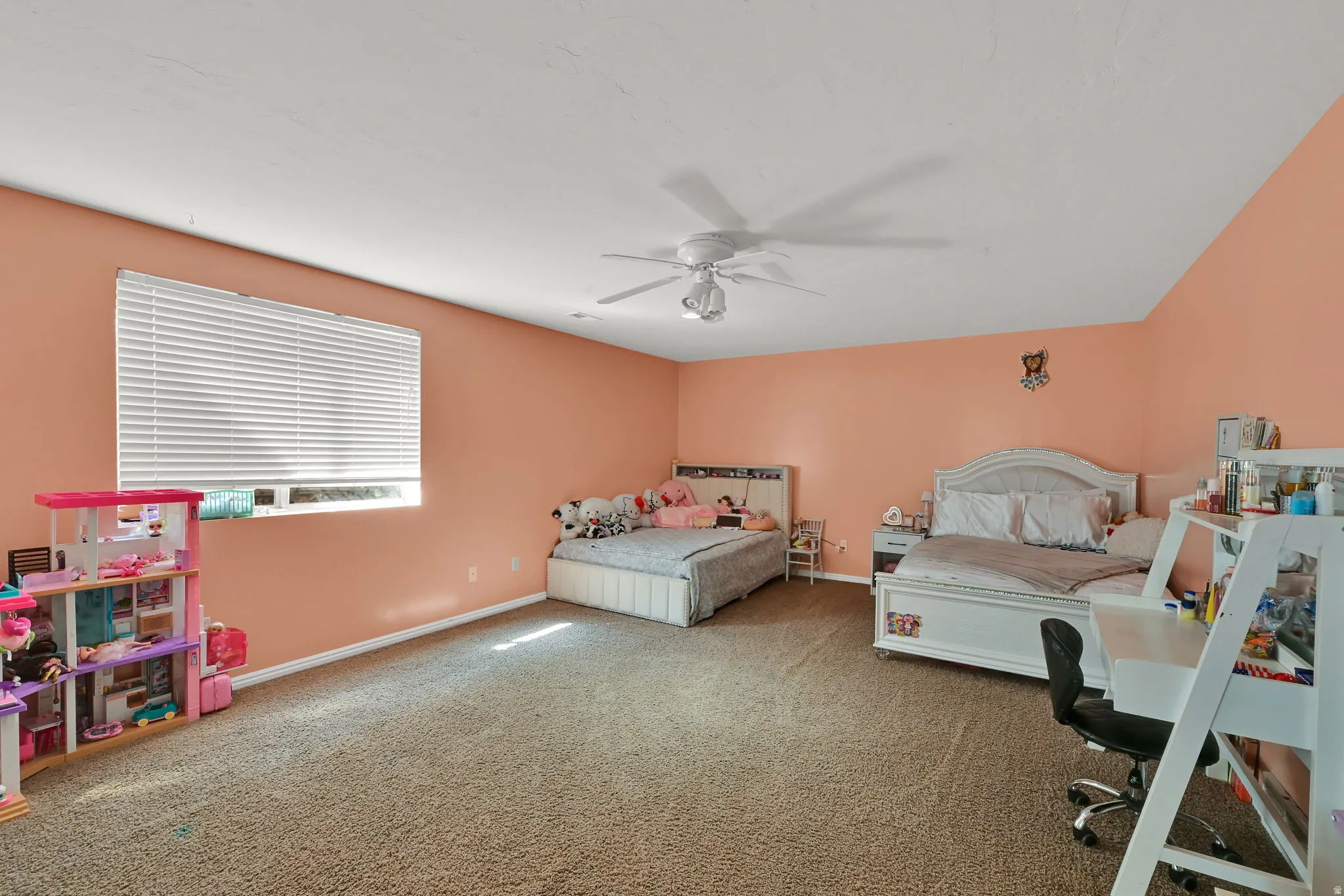 Spacious room featuring carpeting, a window with horizontal blinds, and a ceiling fan with integrated lighting