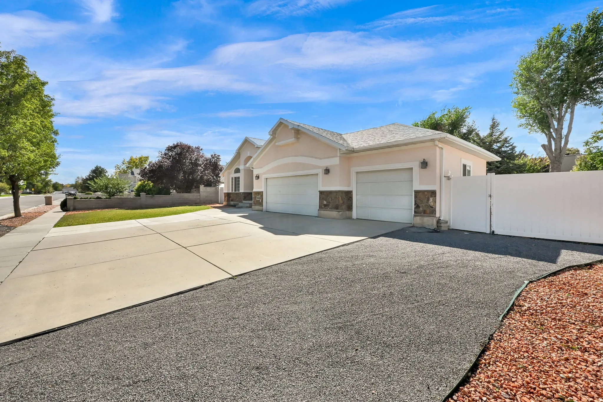 Exterior featuring a two-car garage, stucco finish, stone accents, and a concrete driveway