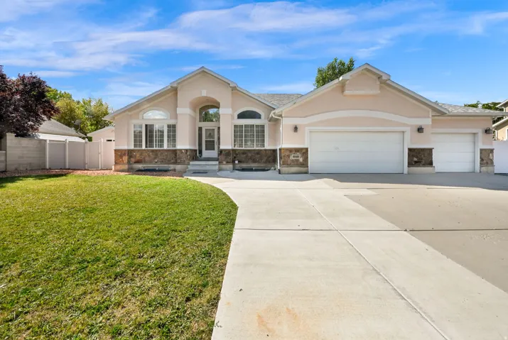 Stucco exterior with stone accenting and a concrete driveway