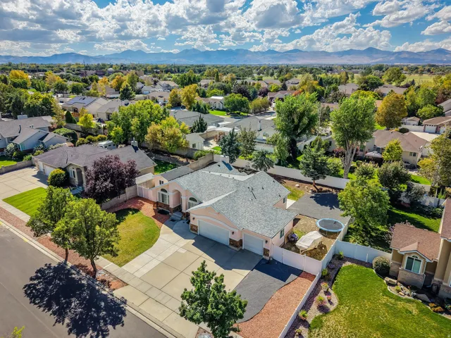 Expansive residential property with a multi-car driveway, attached garage, and mature landscaping