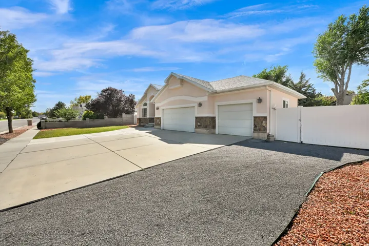 Exterior featuring a two-car garage, stucco finish, stone accents, and a concrete driveway