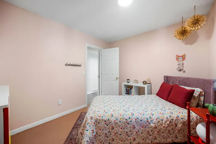 Recessed ceiling light, white trim, wood-finish flooring, and a white interior door