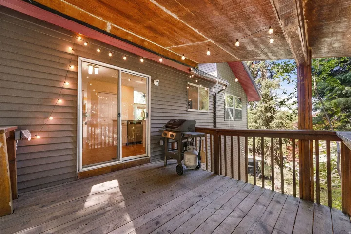 Deck off kitchen Expansive outdoor deck with wood-finish flooring, wood railings, and a wood-paneled ceiling