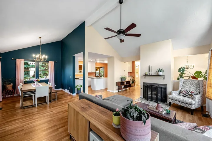Vaulted ceilings, wood-finish flooring, and a fireplace with a tiled hearth