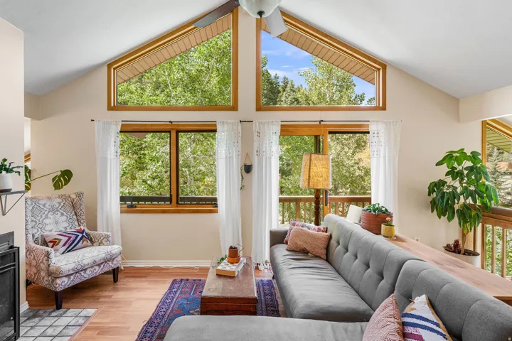Vaulted ceilings with abundant natural light, wood-finish flooring, and a built-in fireplace