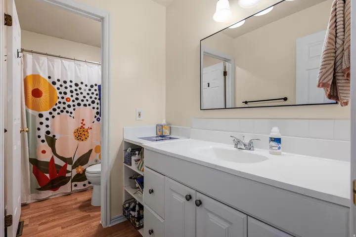 Upstairs bathroom down the hallway from the kitchen. White vanity with integrated sink, chrome faucet, and white countertop