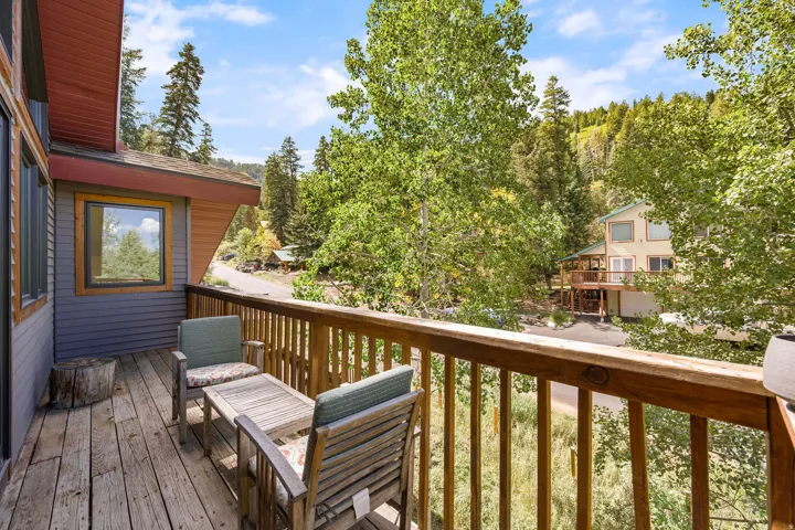 Wood deck with wood railing, featuring horizontal siding, and natural wood window trim