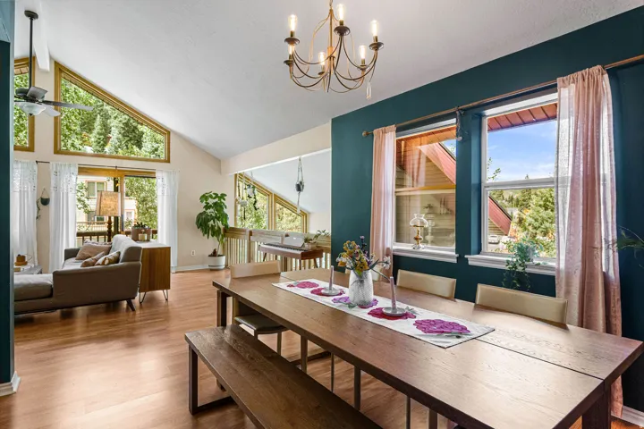 Vaulted ceilings with an exposed beam, wood-finish flooring, and expansive windows