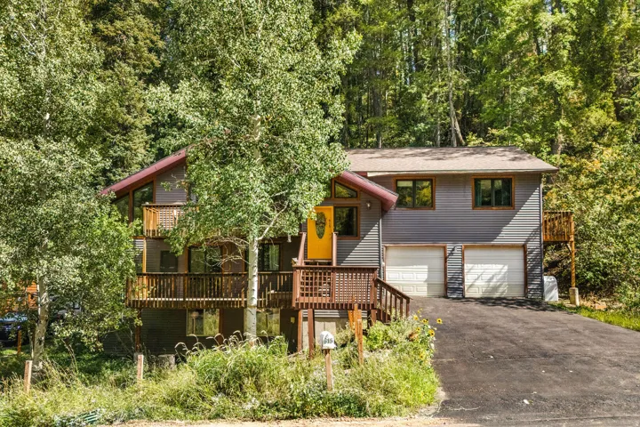 Multi-level residence featuring gray siding and a brown roof