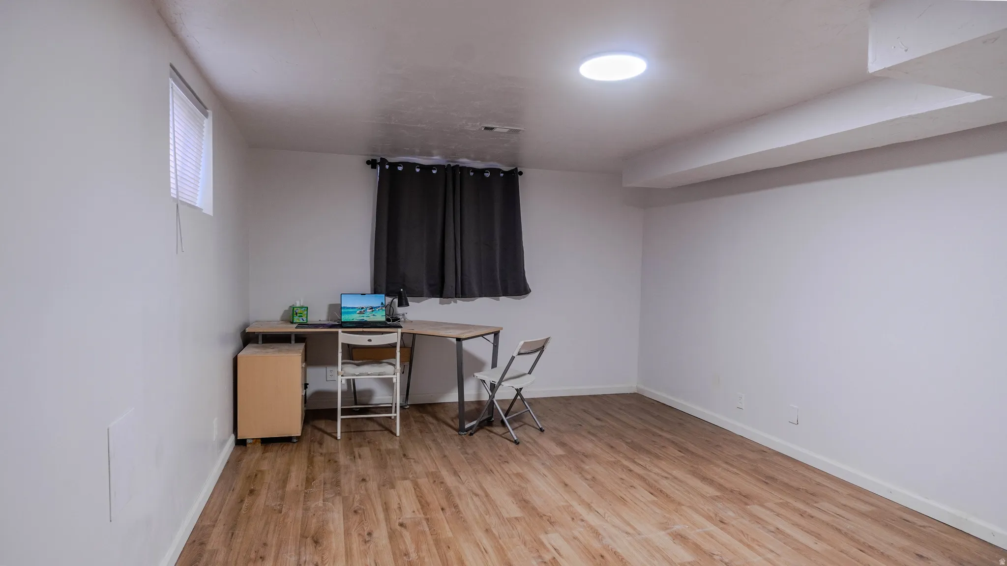 Wood-finish flooring, recessed ceiling light, and a window with blinds