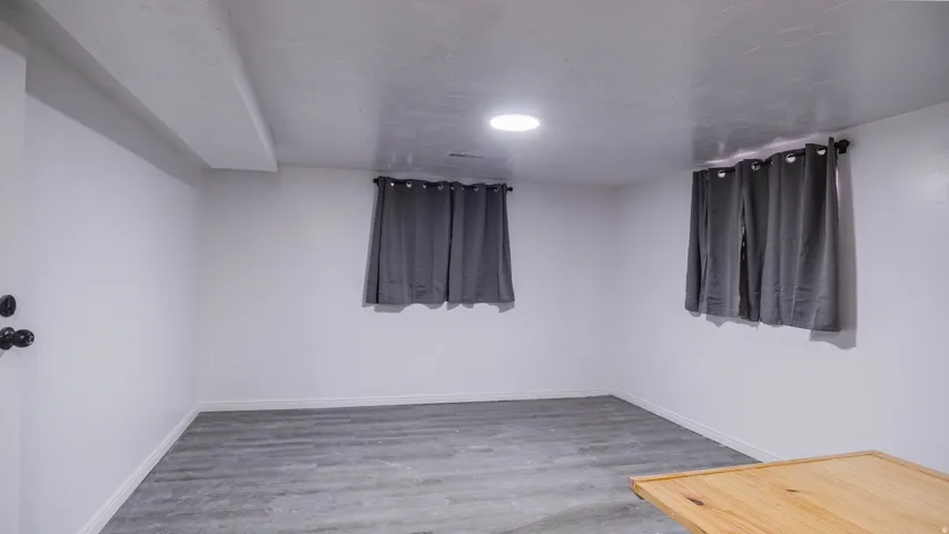 Recessed lighting, wood-finish flooring, white painted walls, and window treatments
