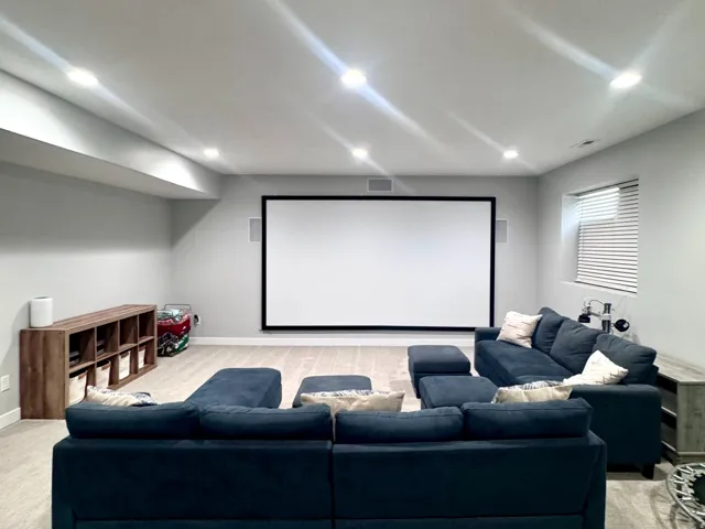 Recessed lighting, large projection screen, wood-finish flooring, built-in shelving, and window with horizontal blinds