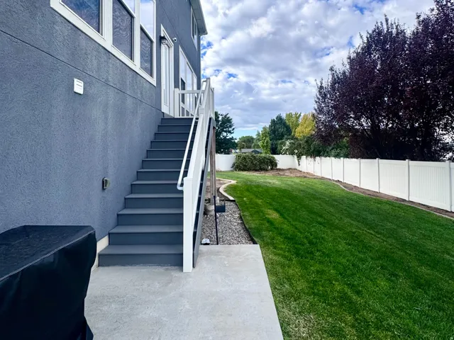Exterior featuring a stucco finish, multiple windows, and a concrete patio