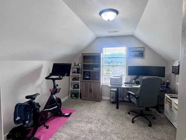 Carpeted flooring, sloped ceiling, recessed window, and flush mount lighting