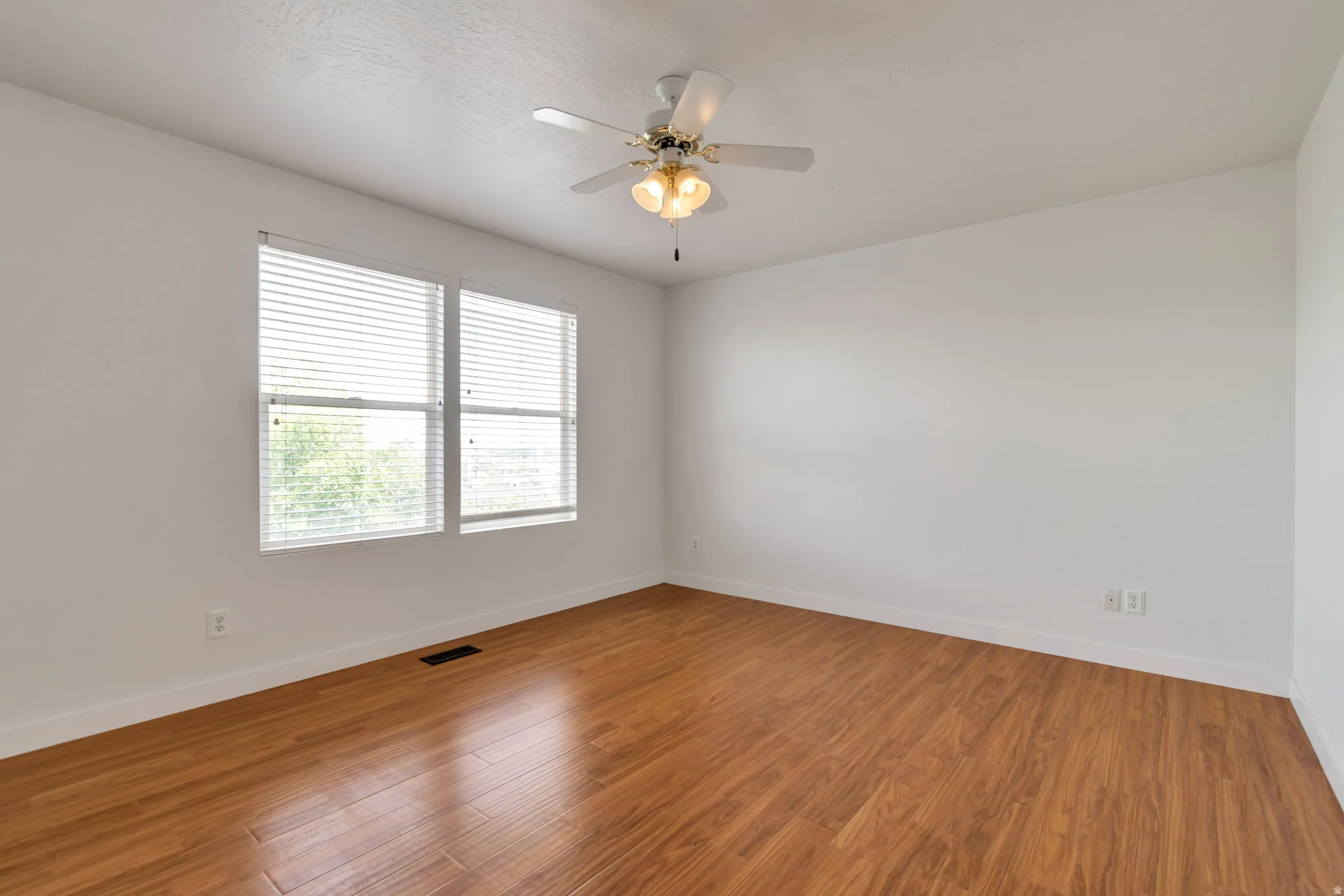 Recessed lighting, wood-finish flooring, and a ceiling fan with integrated lighting