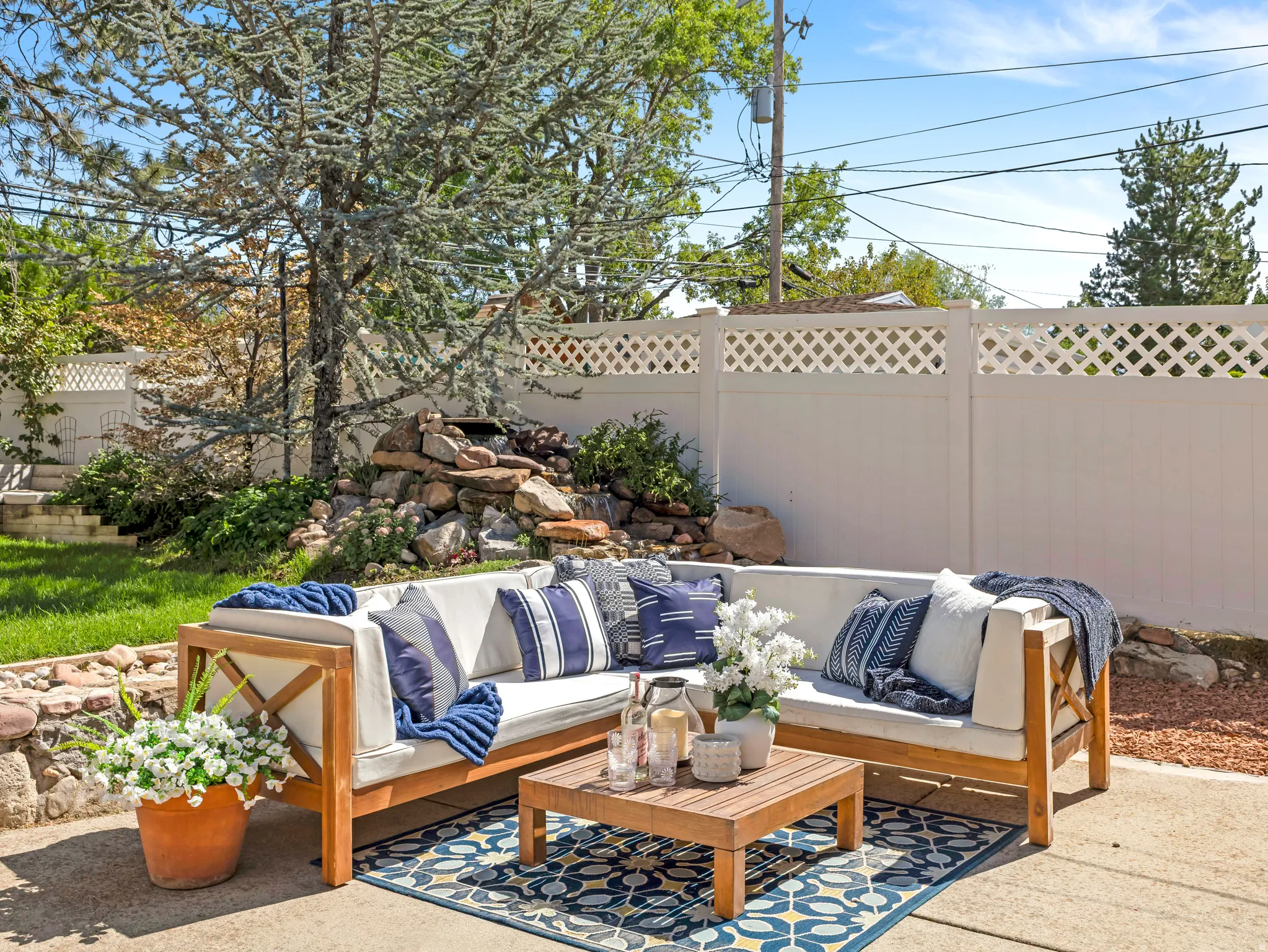 Paved patio area featuring a built-in rock water feature