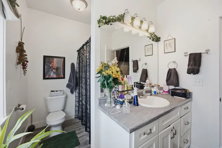Vanity with integrated sink, stone-finish countertop, and white cabinetry