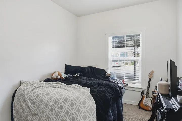 Carpeted flooring, white painted walls, and a window with blinds