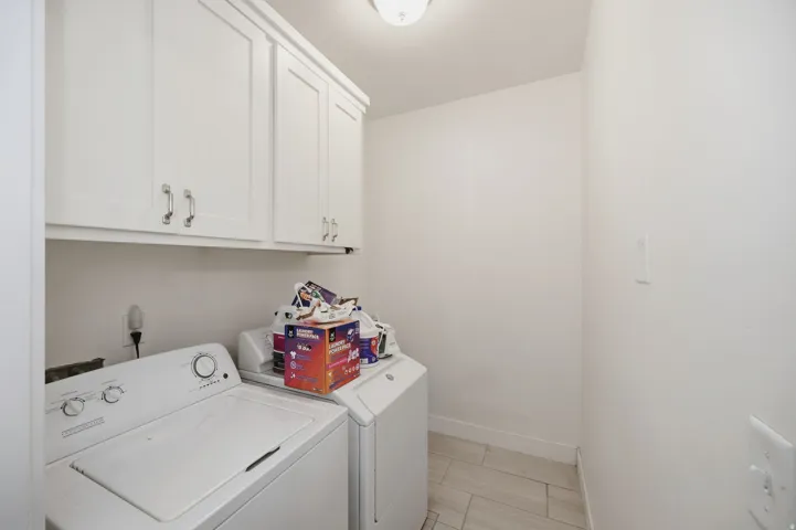 White shaker-style cabinetry with chrome hardware, flush-mount ceiling light, and tile flooring