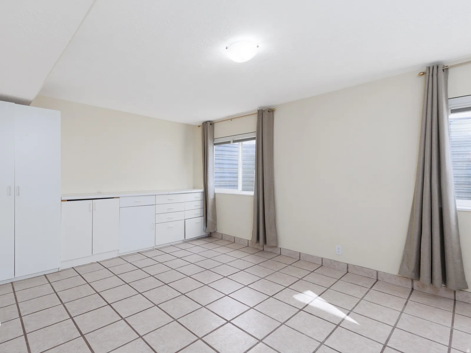 White tile flooring, built-in white cabinetry, integrated storage solutions, recessed windows, and overhead lighting