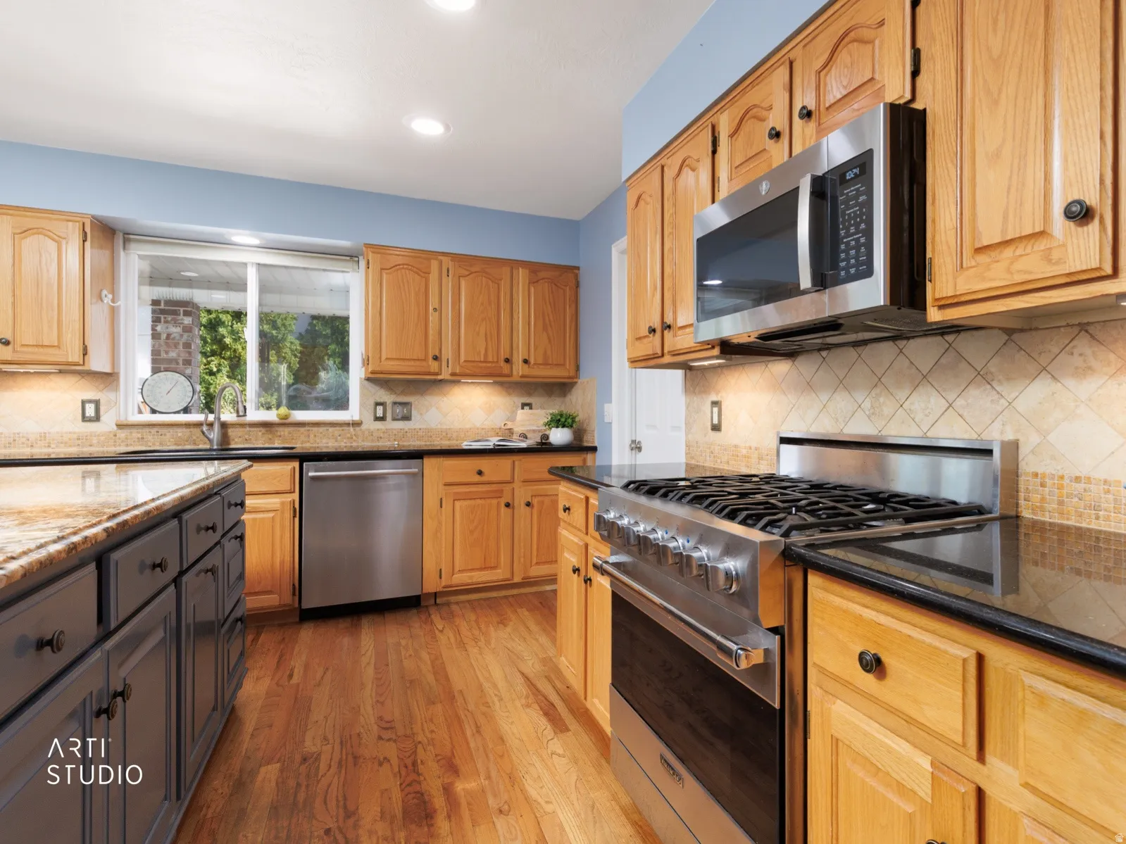 Kitchen featuring wood-finish cabinetry, stainless steel appliances, granite countertops, tile backsplash, and wood-finish flooring