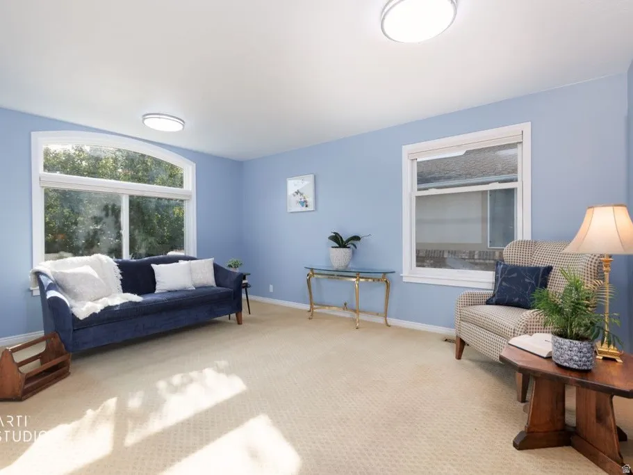Arched picture window, secondary window, recessed overhead lighting, wall-to-wall carpeting, light blue wall finishes