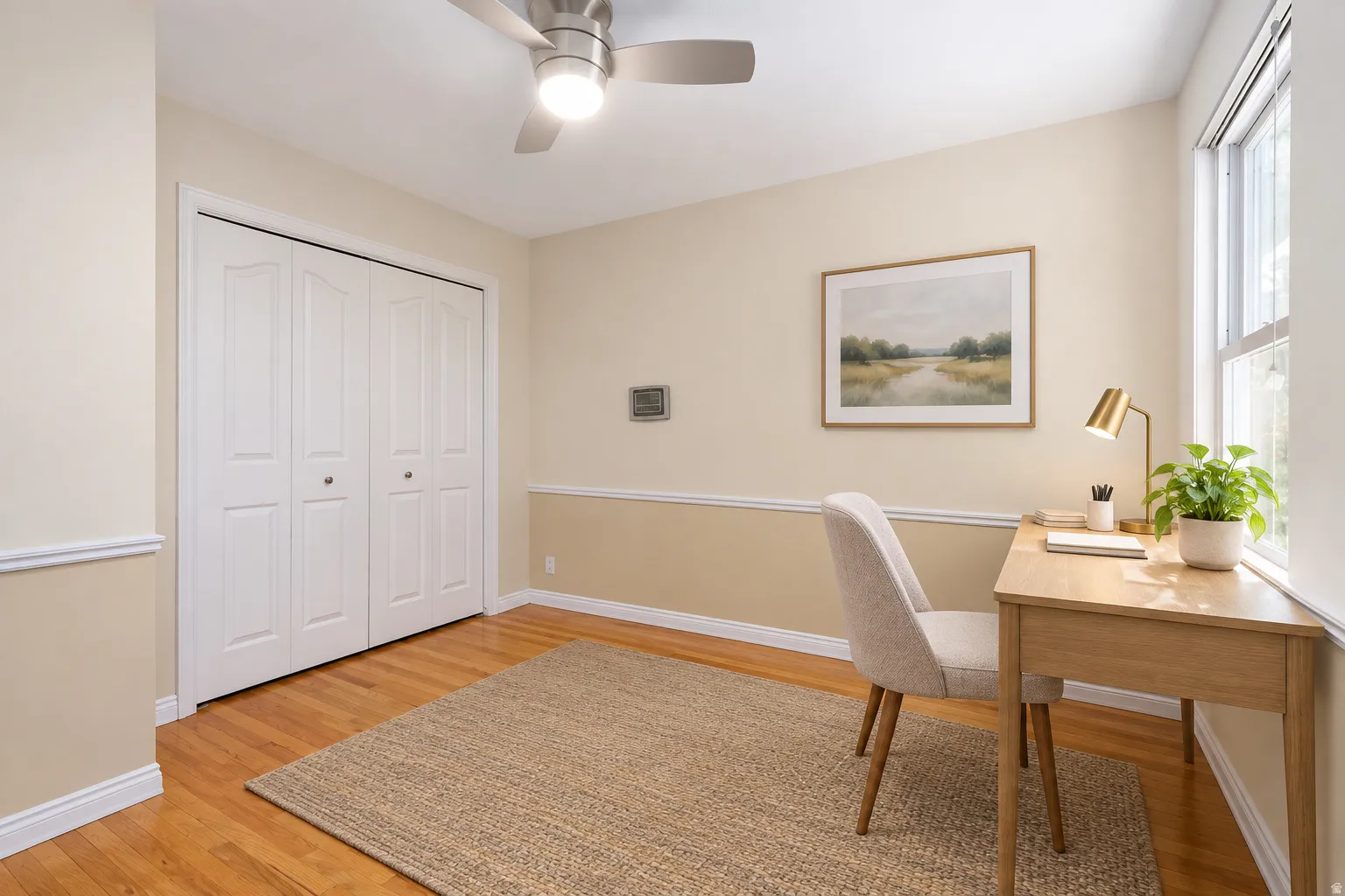 Hardwood flooring, crown molding, double bi-fold closet, ceiling fan with integrated lighting, and natural light from a double-hung window